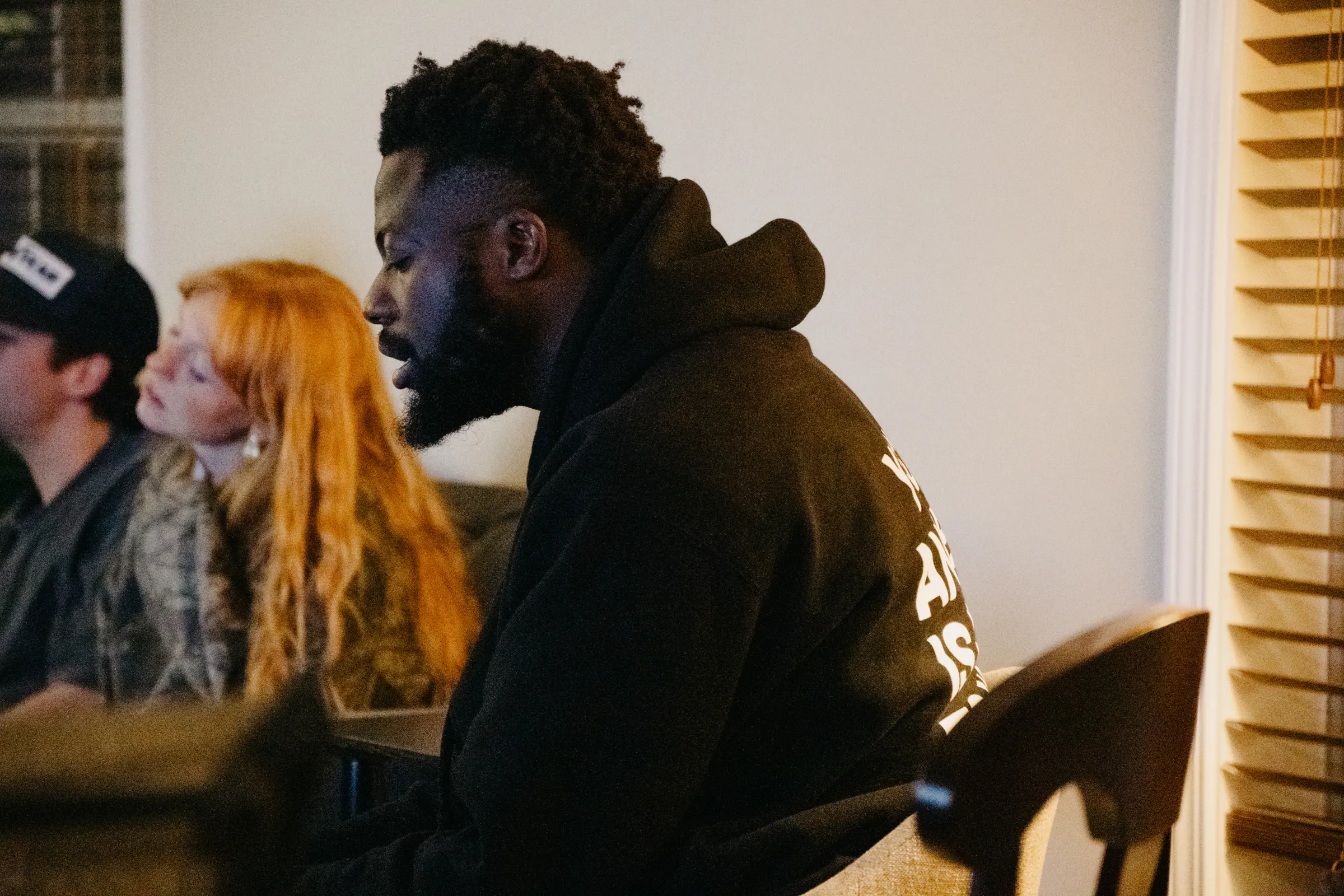 A friend sharing his story in the living room while others listen