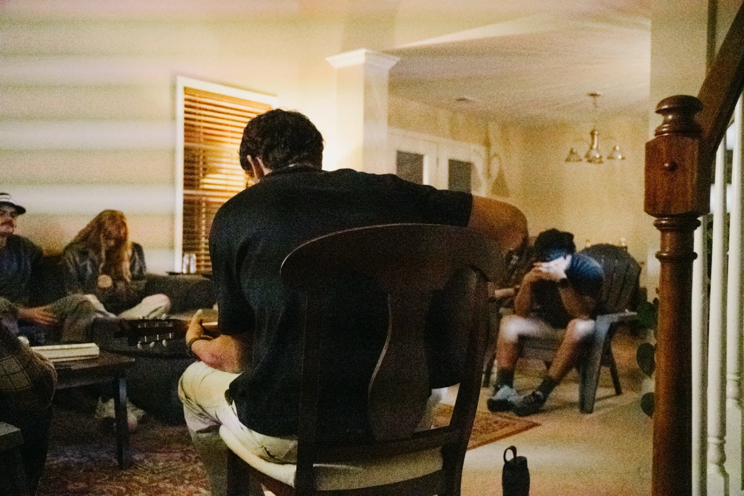 The living room during a SaltHouse night, friends gathered on couches and chairs