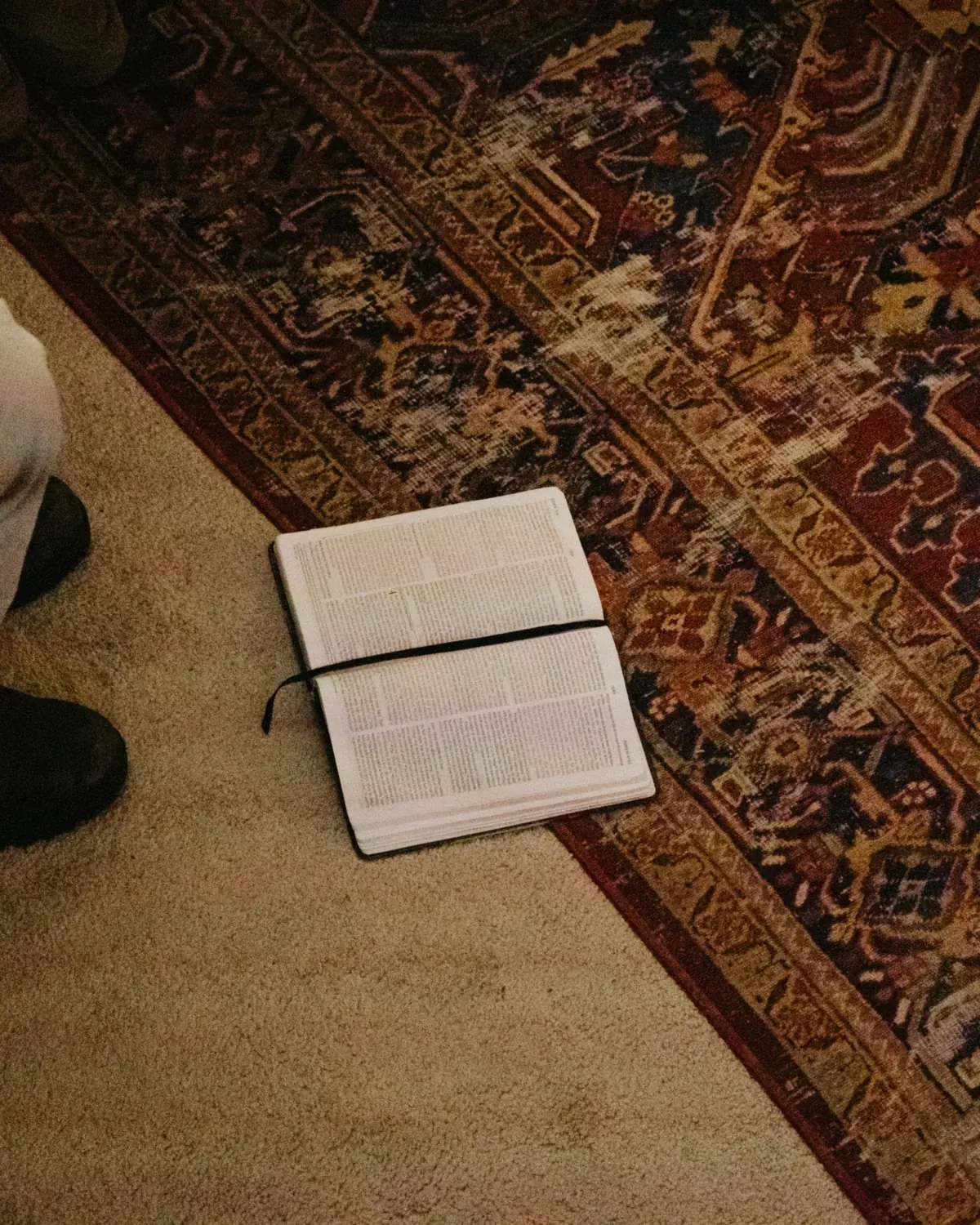 An open Bible on the living room rug during a SaltHouse night
